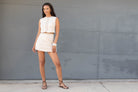 Woman in a beige vest and beige skirt.  Vest and skirt set.