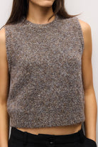 A sleeveless cropped knit sweater vest in a heathered brown and gray melange, worn by a model.