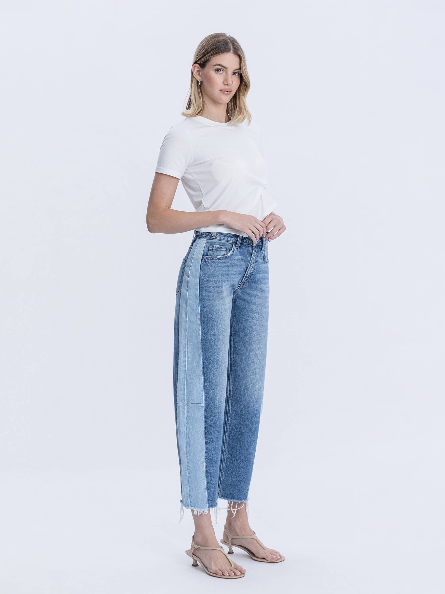 Woman modeling high rise two tone raw hem barrel jeans