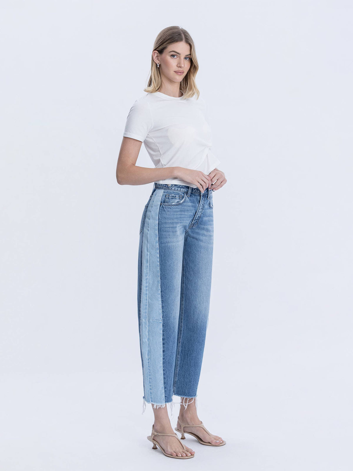 Woman modeling high rise two tone raw hem barrel jeans