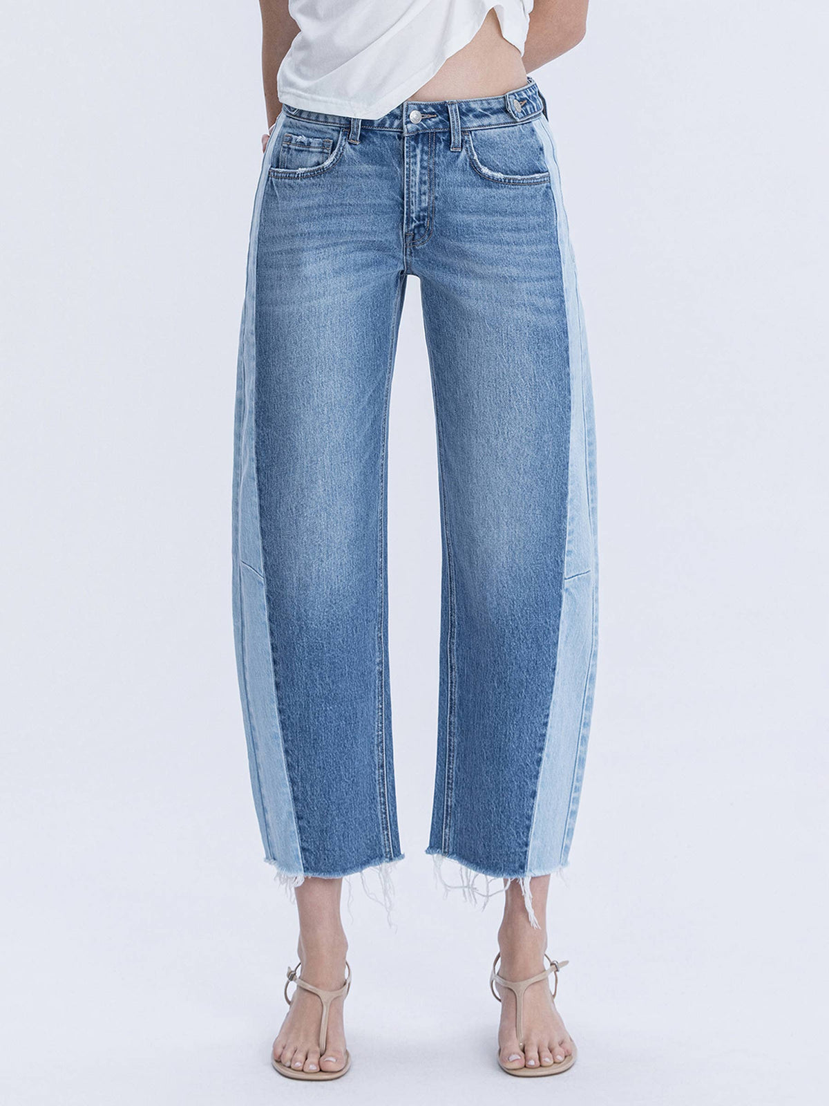 Woman wearing high waisted two tone barrel raw hem denim jeans